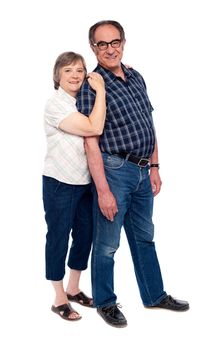 Full length shot of an aged couple. Woman resting her head on mans shoulder