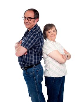 Trendy smiling senior love couple standing back to back with crossed arms