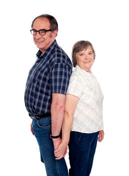Senior affectionate couple posing back to back. Holding hands