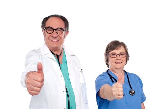 Mature medical professionals showing thumbs up at camera