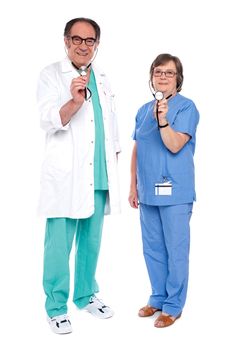 A medical team of doctors holding stethoscope for checkup. All on white background