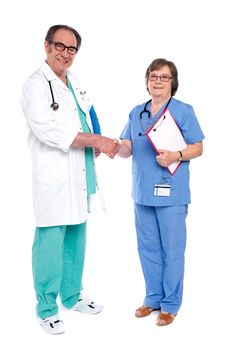 Full body portrait of two medical representatives shaking hands