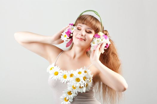 The girl listening music in headphones of flowers.