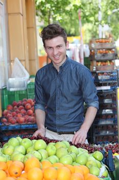 Smiling young customer buying fruits at grocery store