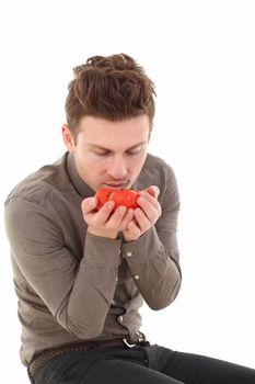 Vertical portrait of young man smelling tomatoes