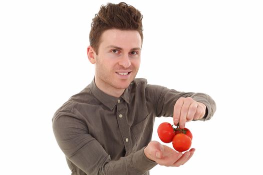 Young man isolated smiling and offering fresh tomatoes
