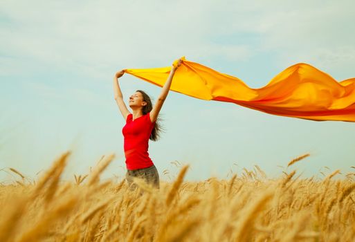 Teen girl at a wheat field with yellow fabric