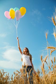 Teen girl at a wheat field with colorful balloons