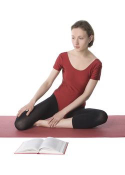 Young woman in sports clothes reading a book