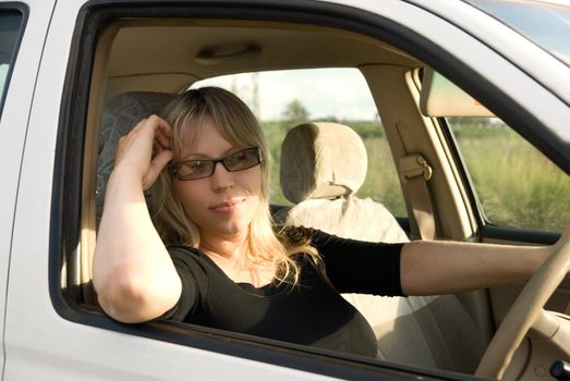 young woman travelling by car on nature background