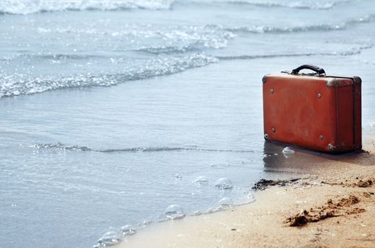 Lost orange handbag on the beach