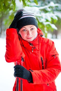 Portrait of a happy woman with ski poles in the winter woods