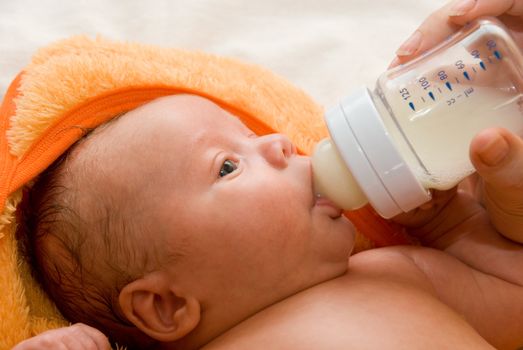 Mother give drink her baby boy by feeding bottle