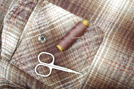 Sewing tools on a brown textile. Horizontal photo
