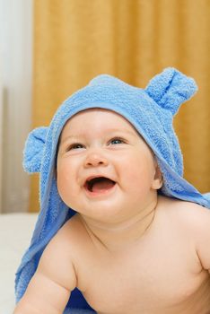 Small smiling baby in blue towel