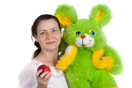 The woman with an apple and a soft toy it is isolated on a white background