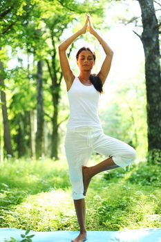 yoga woman on green grass in forest