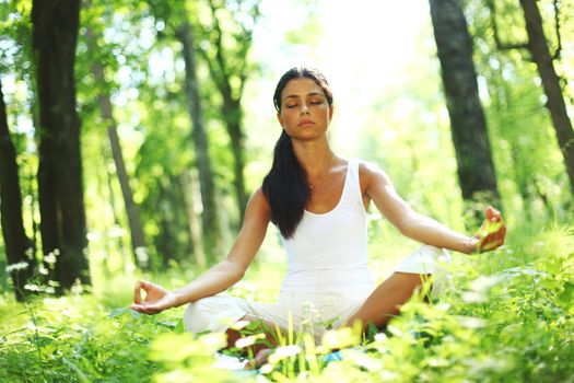 yoga woman on green grass in forest