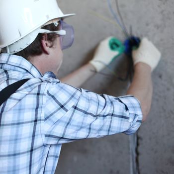 worker puts the wires in the wall