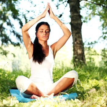  yoga woman on green grass in lotus pose
