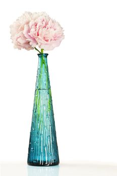 Beautiful pale pink peony flowers in a blue cristal vase over white background with copy space.