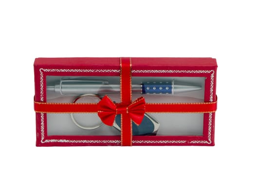 Pen and key ring packed in red gift box with ribbon isolated on white background.