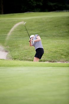 woman is playing golf on course  in summer in a golf-club