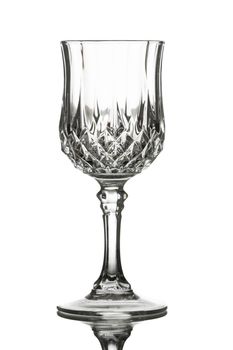 An empty red wine glass on a reflective table. Isolated on white.