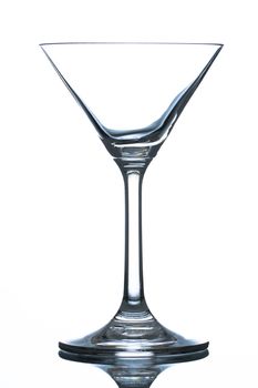 An empty martini glass on refelctive surface. Isolated on white.