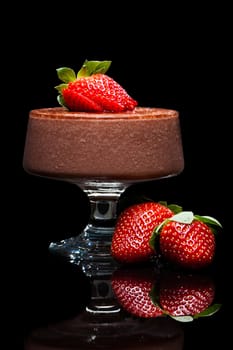 Chocolate mousse dessert with delicious red strawberries. Isolated on black.