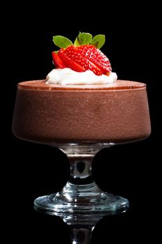 Chocolate mousse dessert with strawberries and cream. Isolated on black.