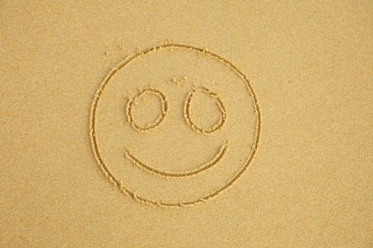 Smiling face drawn on beach sand