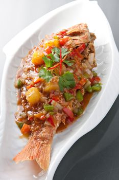 Freshly prepared Thai style whole fish red snapper dinner with tamarind sauce.