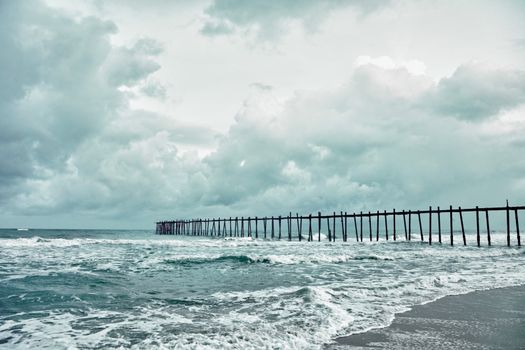 The wooden old jetty over the stormy sea