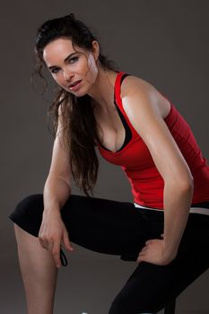 A young beautiful woman sitting down and having a rest after exercise.