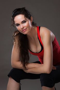 Beautiful sexy young woman sitting down having rest after exercise