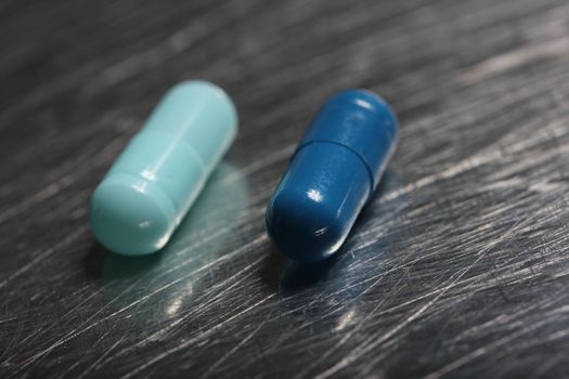 colored medicinical capsules on a steel plate