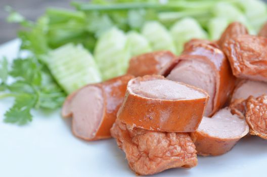 fried sausage served with fresh vegetable on white dish