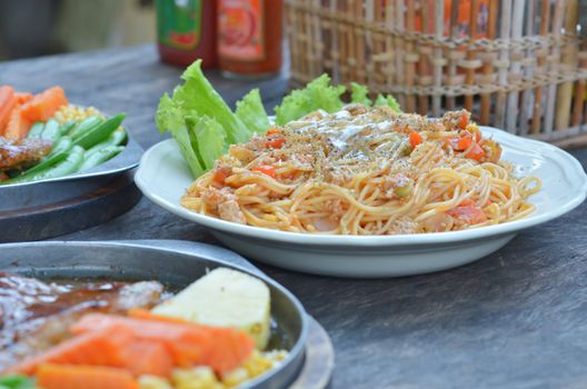 Spaghetti  with tomato sauce and beef steak  , mixed food on table