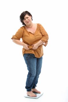 Women with overweight standing on a scale and looks sad - cutout on white