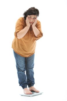 Middle-aged woman stands on a scale and is shocked - cutout on white