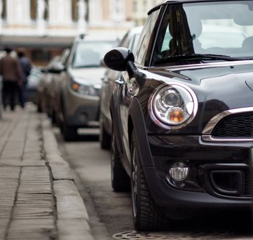 Fragment of Mini Cooper car standing at sidewalk