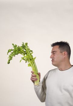 Guy holding a bunch of celery, diet frustation concept