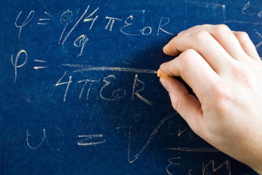 Stock photo: an image of a hand writing formula on a blackboard