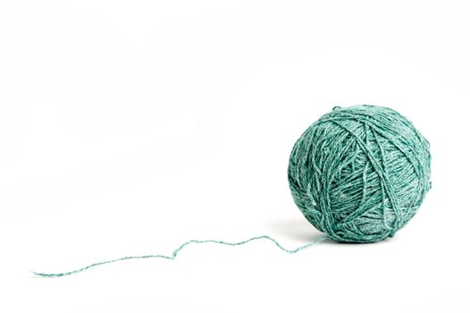 An image of a ball of green yarn on white background