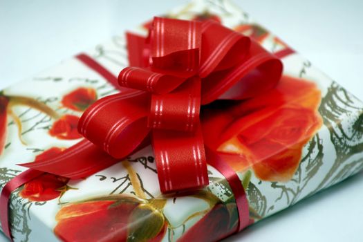An image of red ribbon on the box with present