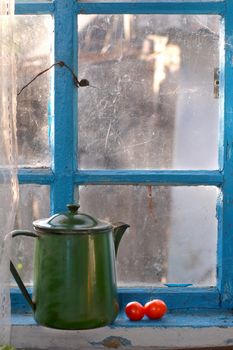 The image of an old teapot on a window sill