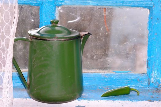 Still-life from an old teapot and green pepper
