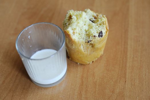 An image of a cake and a glass with some milk on a table
