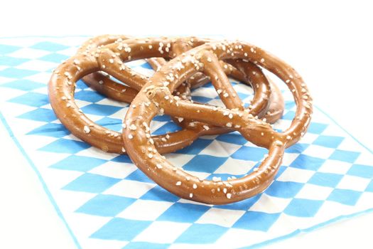 Pretzels with coarse salt on a Bavarian napkin on a light background